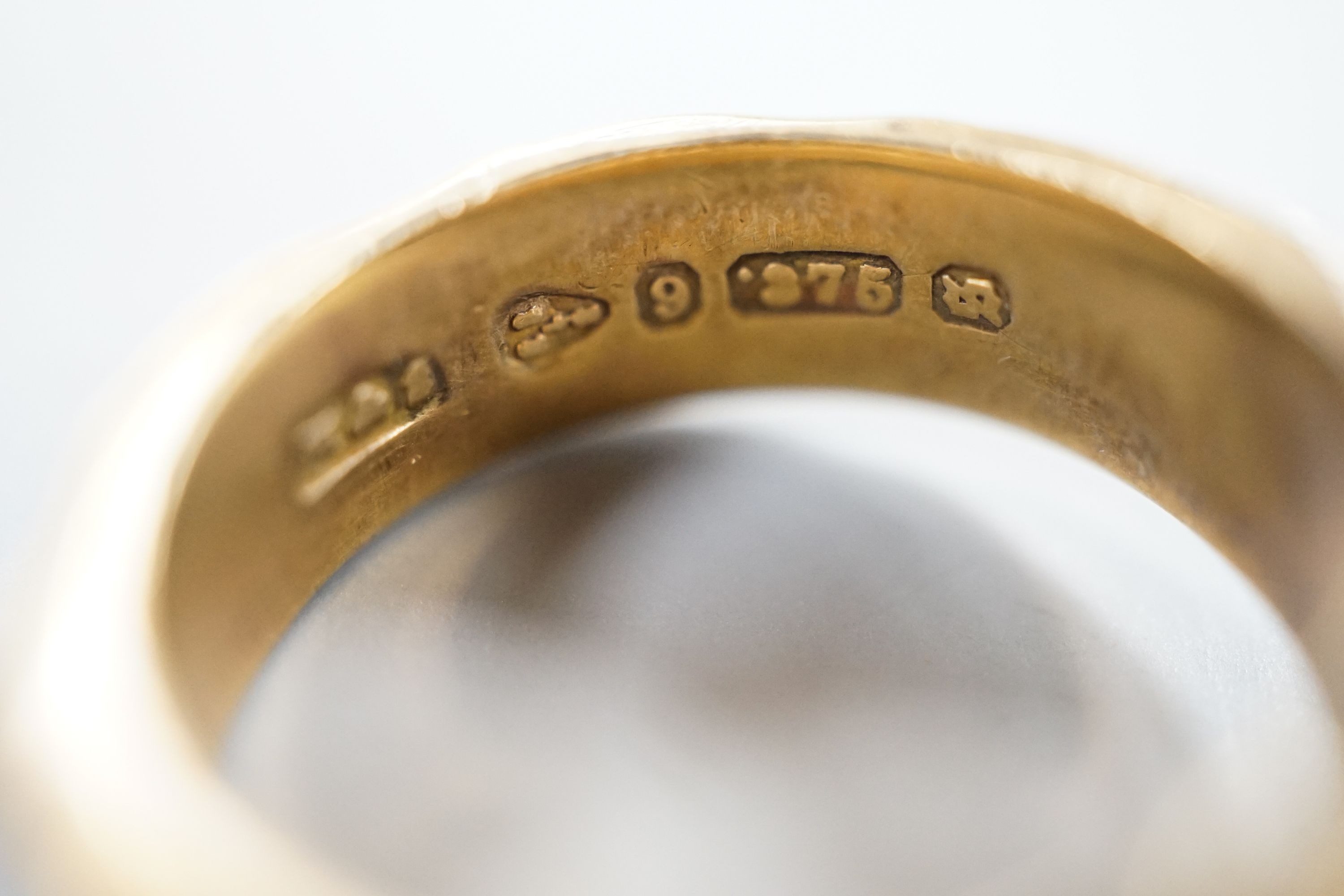 A Scottish pierced 14ct gold band, hallmarked for Edinburgh, 1962?, maker G & TW, size K/L, 3.8 grams and two 9ct gold signet rings, including one with plaited hair within the shank, hallmarked for Chester, 1881, gross 8